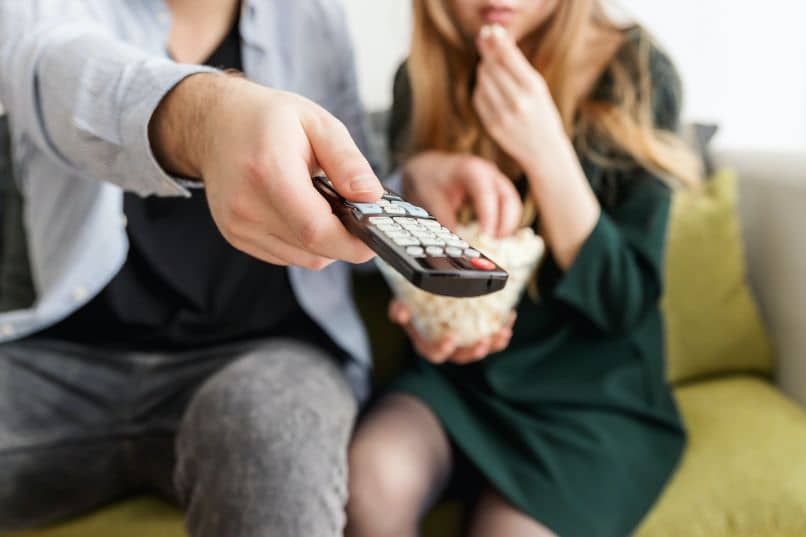 couple watching tv with remote control