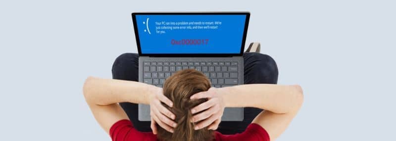 person holding head seeing error on laptop